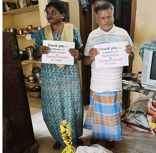 two people holding signs in a living room